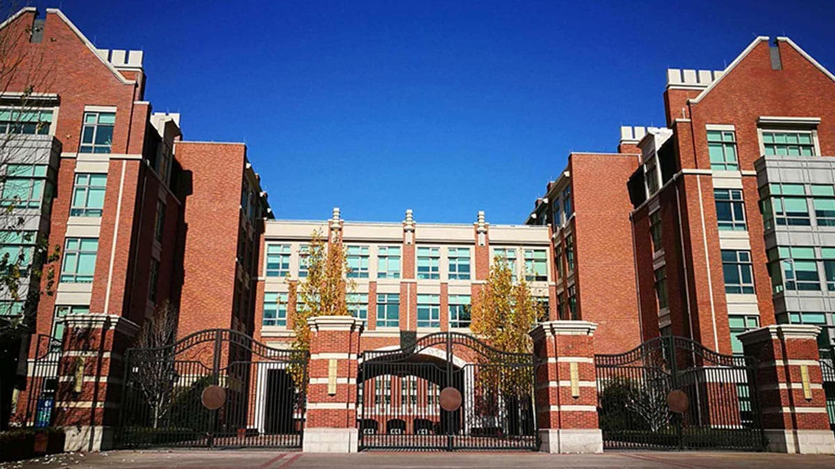 Beijing Keystone Academy campus buildings with red brick facade and iron gates