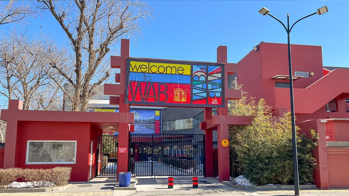 Western Academy of Beijing entrance with colorful welcome sign and red exterior walls