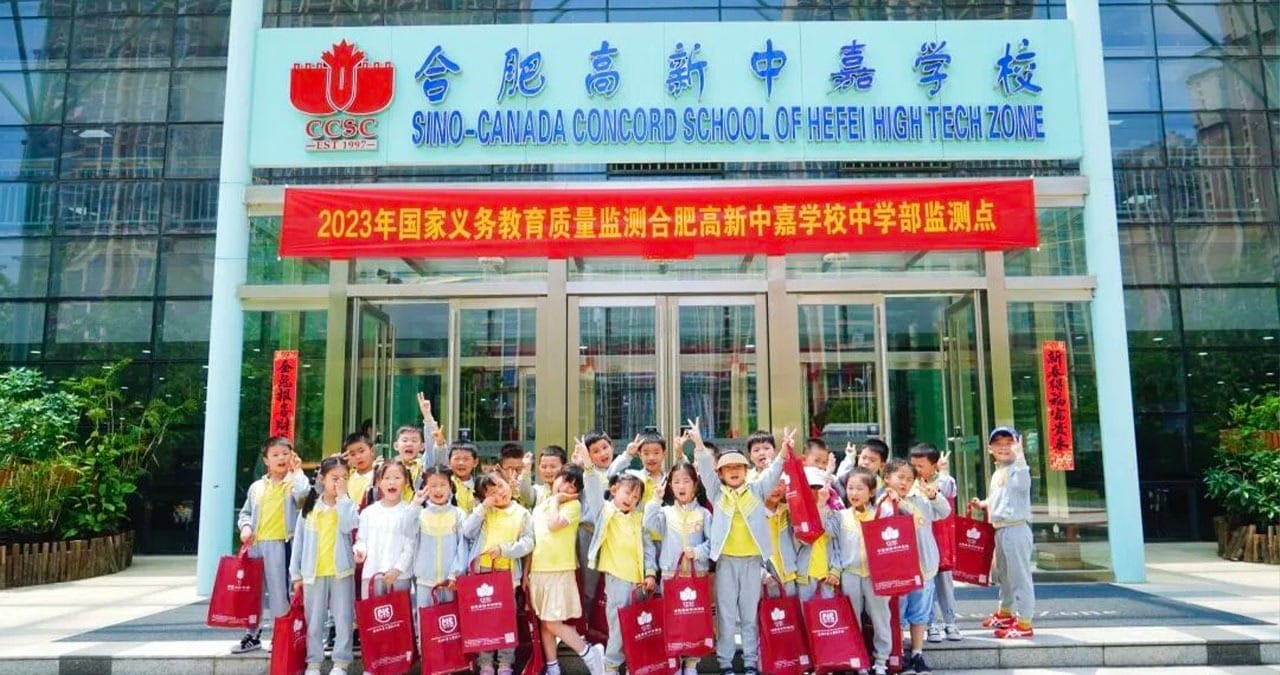 Hefei High-tech Sino-Canadian School students celebrating outside main entrance