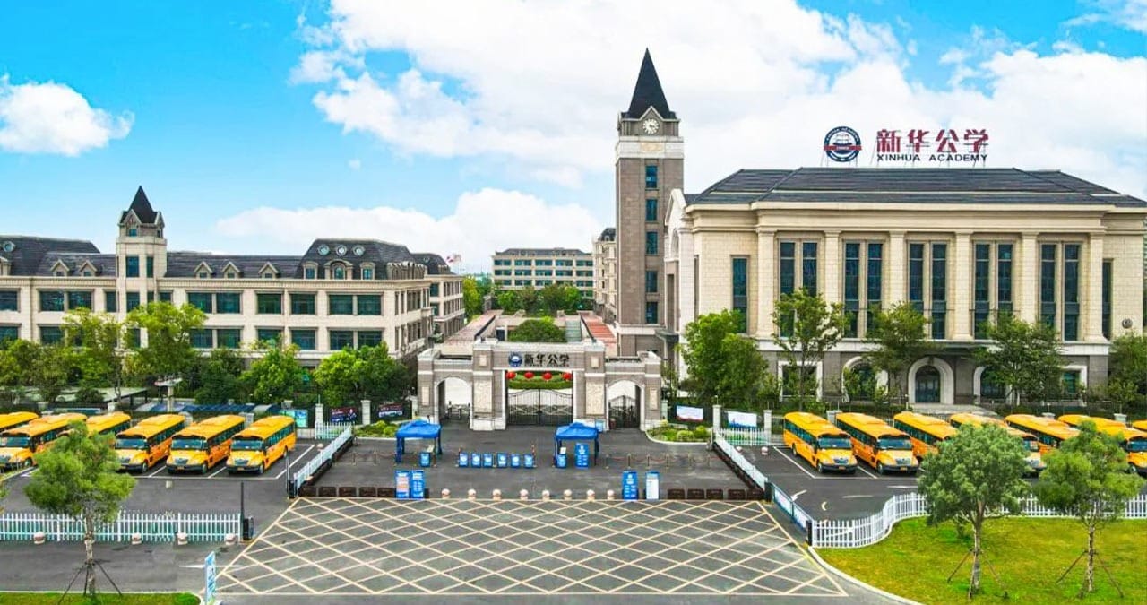 Hefei Xinhua Academy campus aerial view with clock tower and school buses