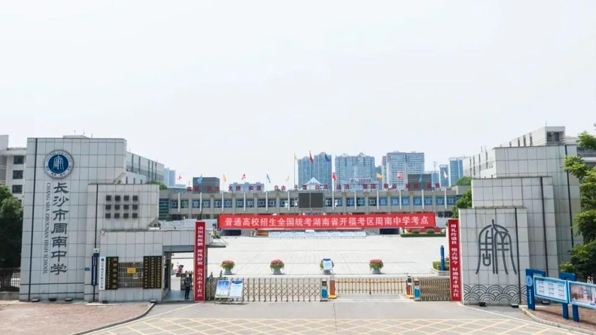 Zhounan High School main entrance gate with modern campus buildings and red banner
