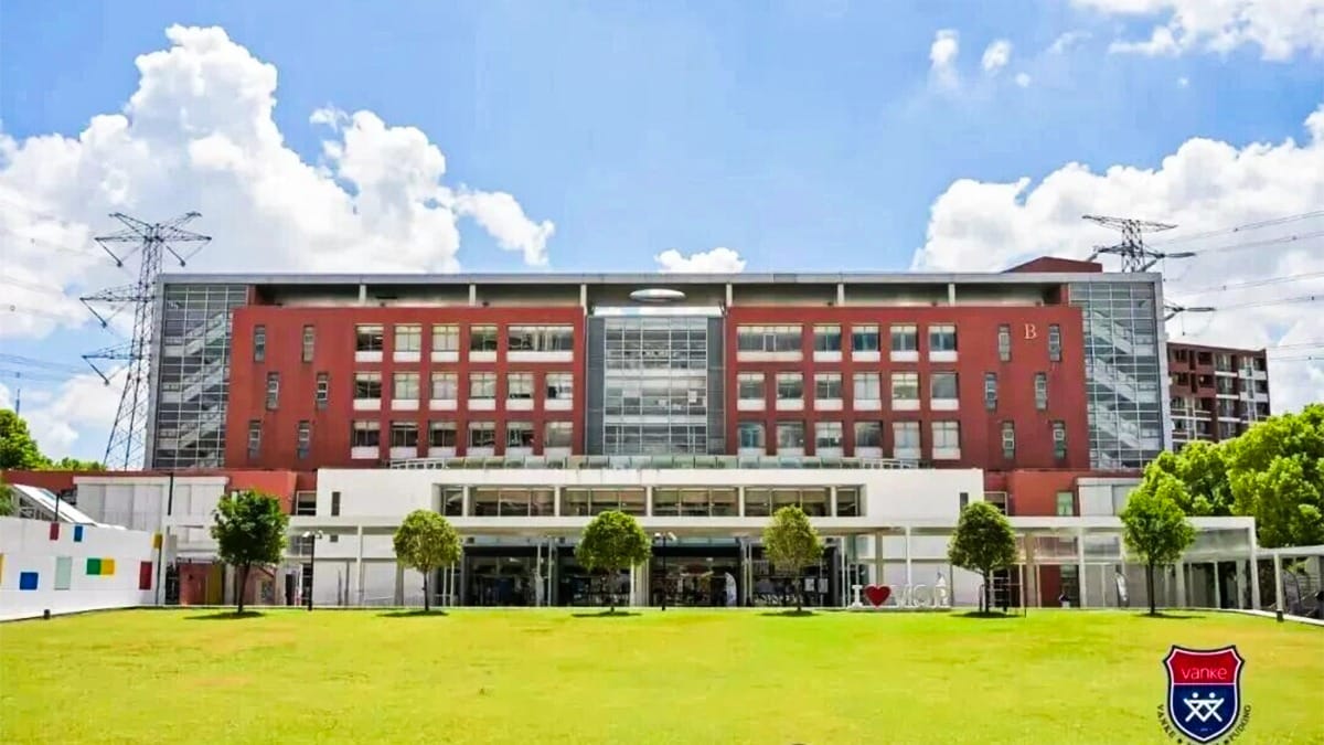 Vanke School Pudong red-brick campus building with open green lawn and trees