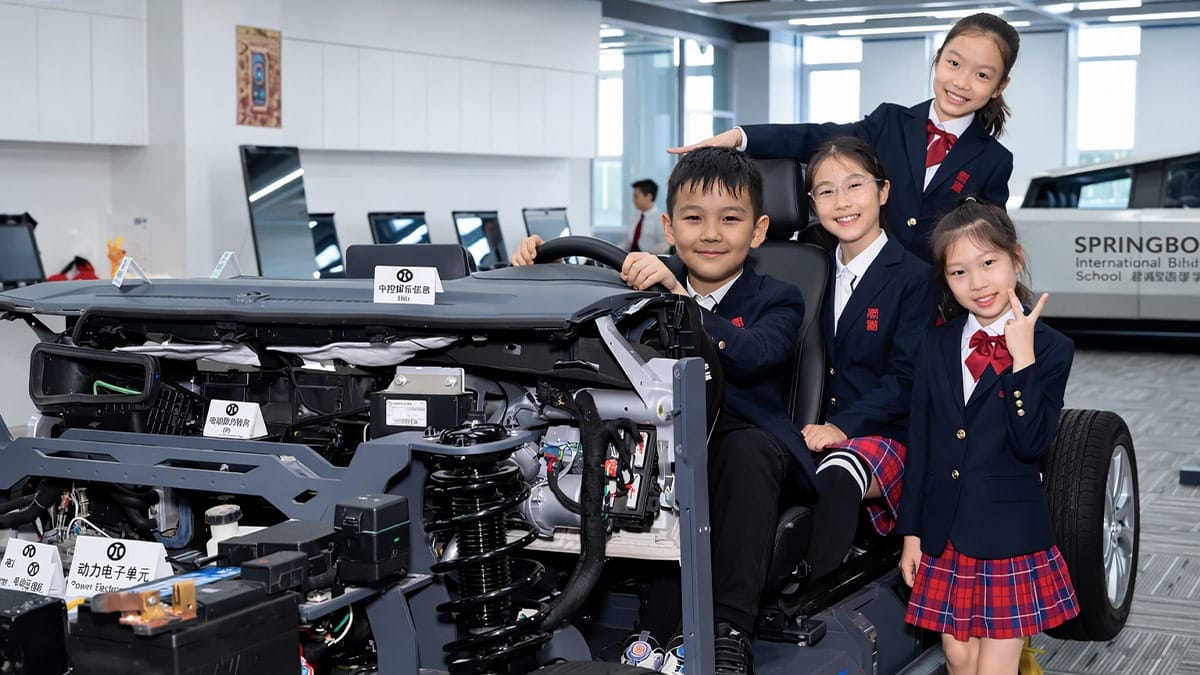 Arman and Aigul alongside other learners exploring electric vehicle engineering at Beijing STEM School.