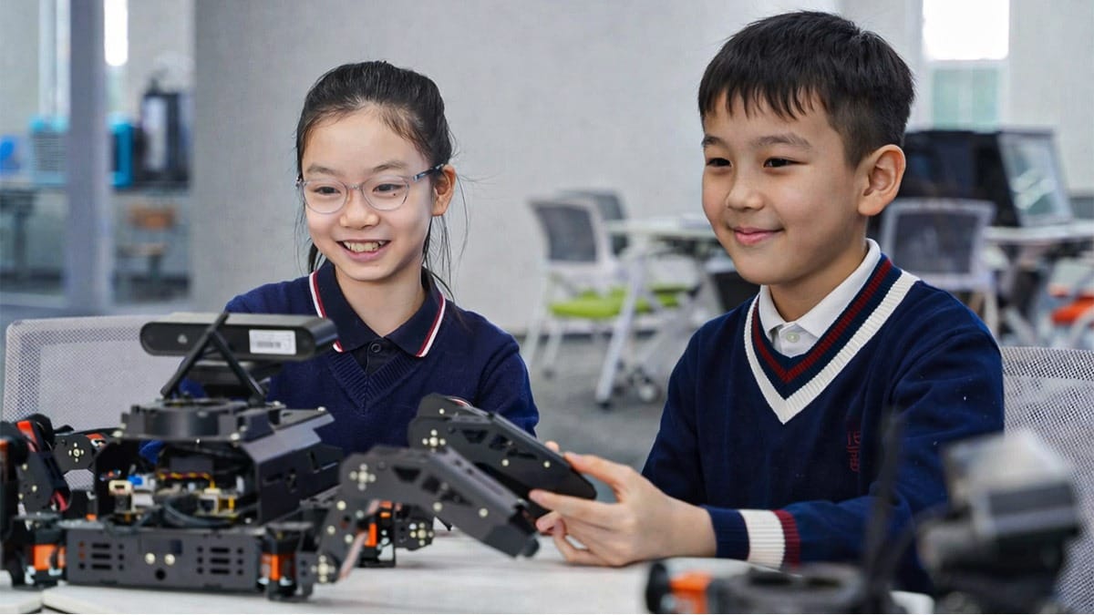Arman and Aigul programming a robot arm during Beijing STEM education class