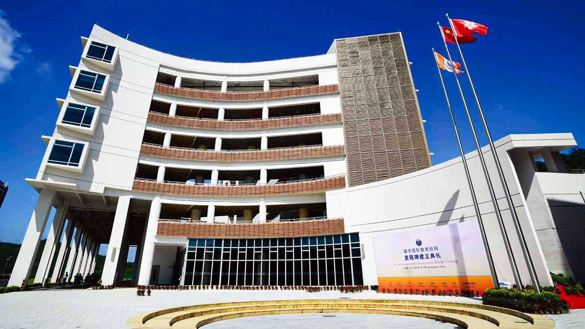 Yew Wah International Education School Guangzhou curved campus building with flags at ceremony