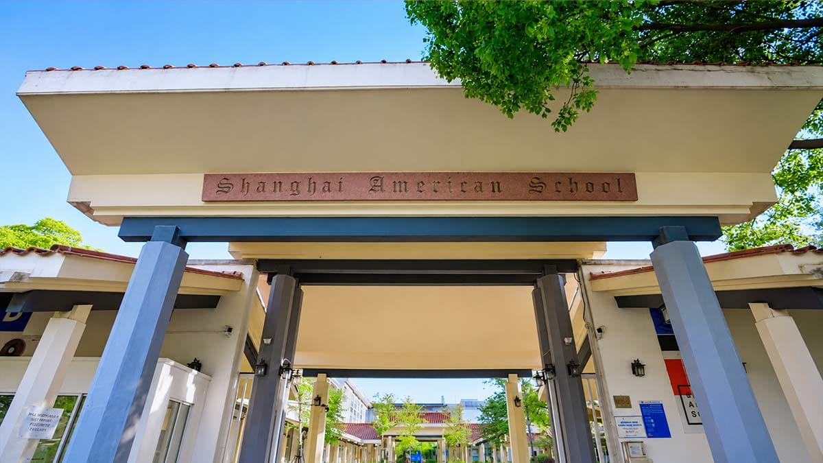 Shanghai American School entrance gate with tree-lined campus walkway in China