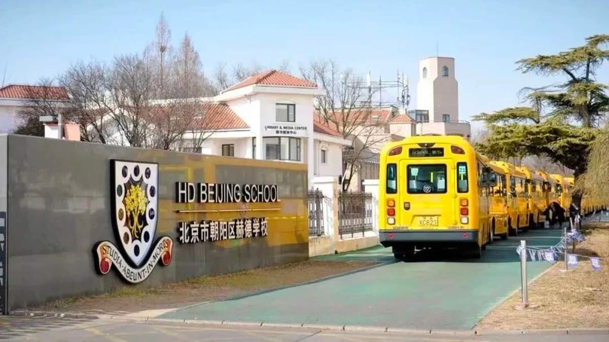 HD Beijing School entrance sign with yellow school buses lined up on campus