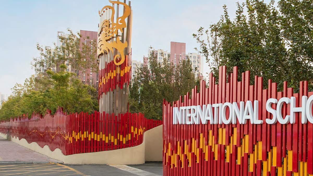 International School of Tianjin entrance with red gold artistic fence and dragon sculpture