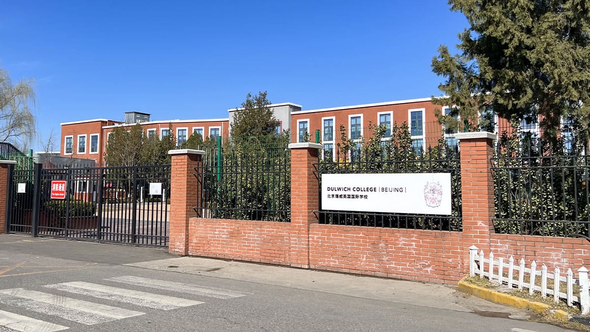 Dulwich College Beijing brick campus exterior with gated entrance and school sign