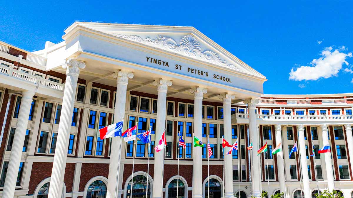 Hainan Yingya St Peter's School grand neoclassical facade with international flags