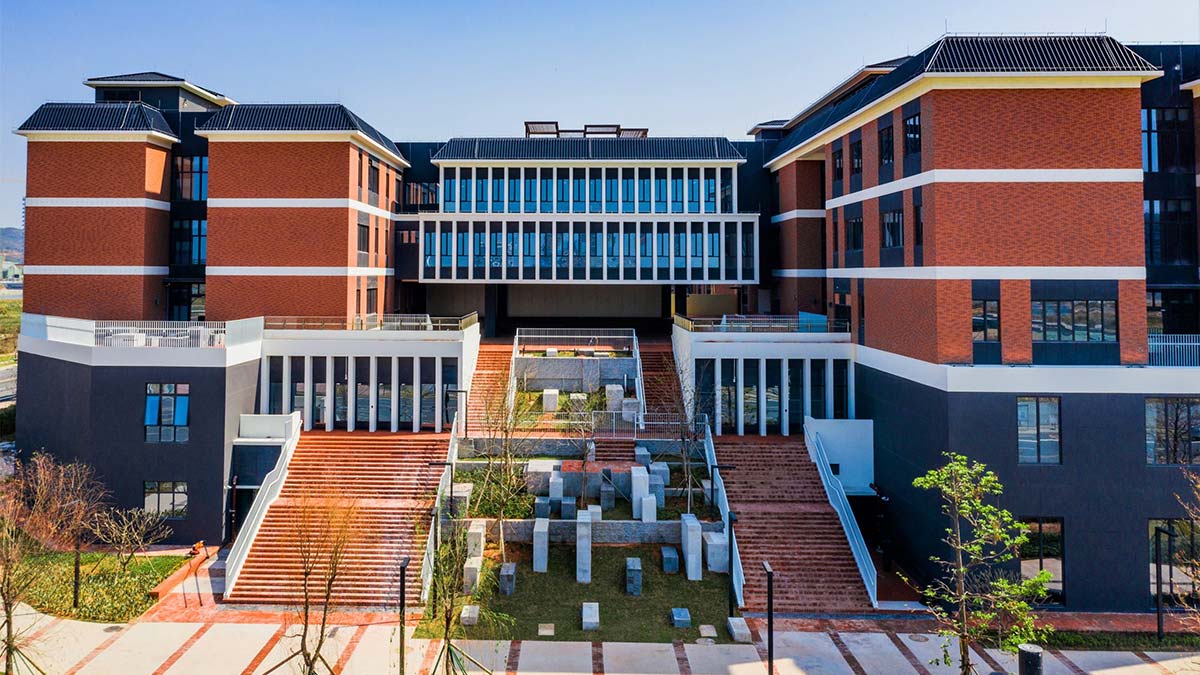 Harrow LiDe School Hengqin campus courtyard with terraced steps and modern facade