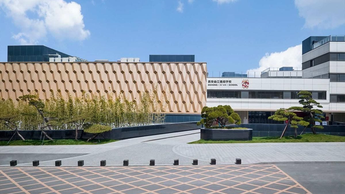 Dehong Xi'an School modern campus entrance with geometric facade and crest
