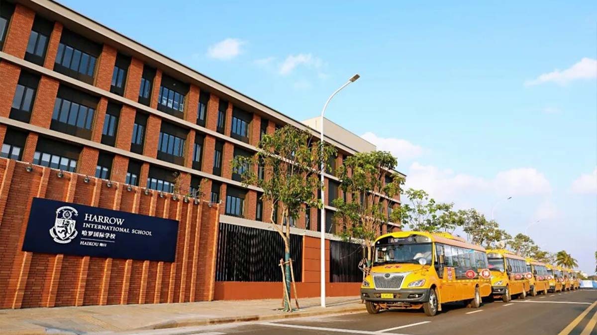 Harrow LiDe School Haikou campus building with brick facade and school buses lined up