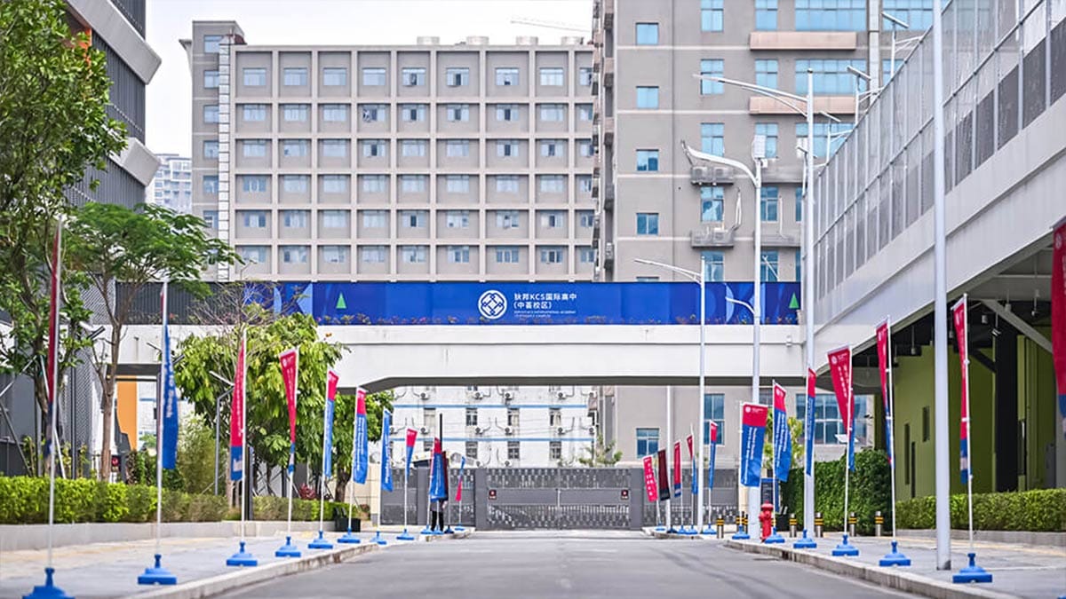 Dipont KCS International High School Zhonghui Campus entrance with blue banner and flags