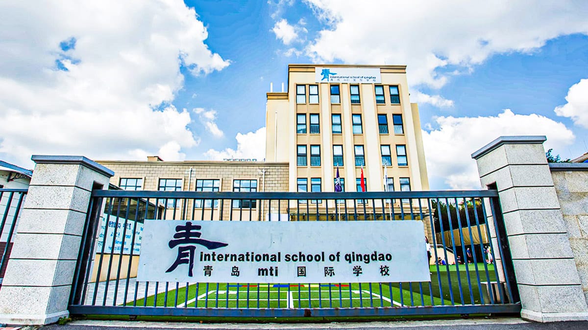 International School of Qingdao main gate with bilingual sign and campus tower