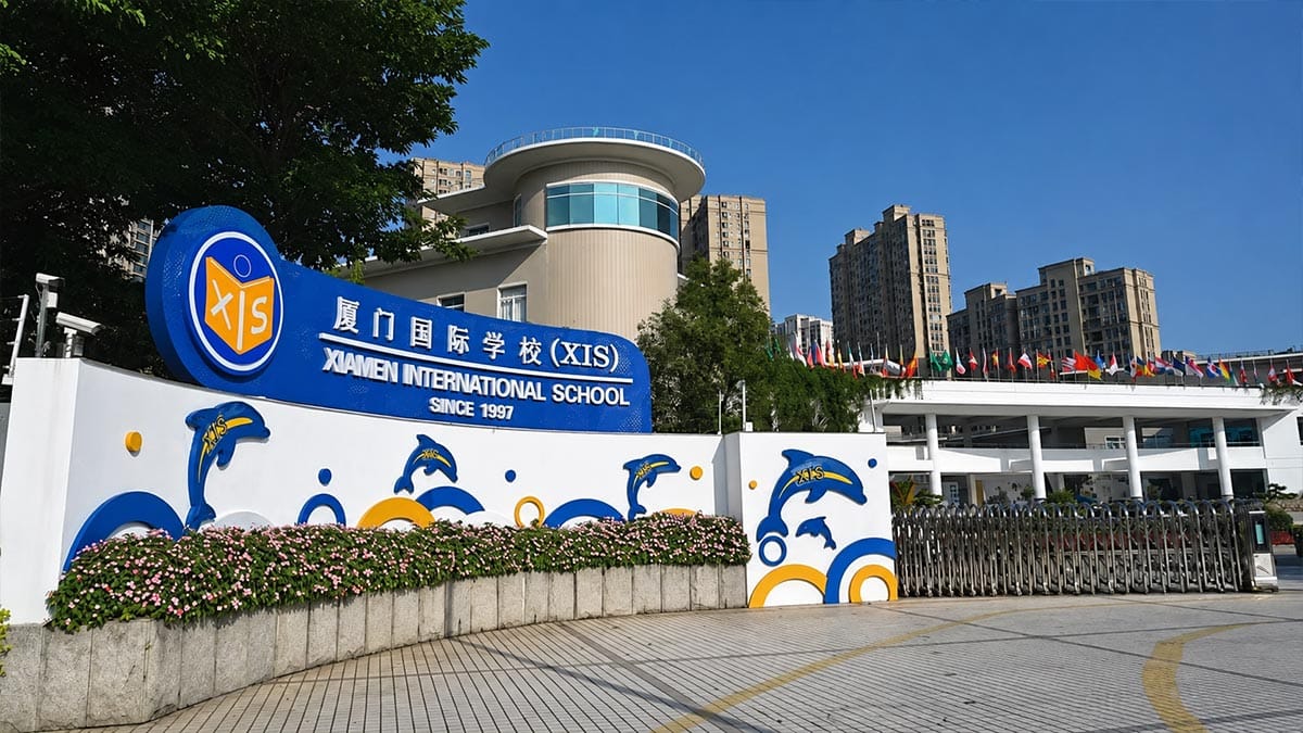 Xiamen International School XIS entrance sign with dolphin mural and national flags