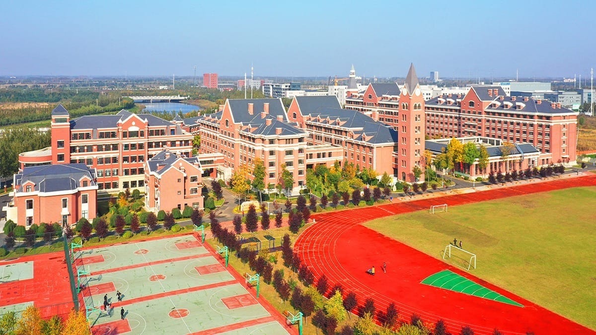 Harbin Meijia Foreign Language School campus aerial view with red track and sports facilities