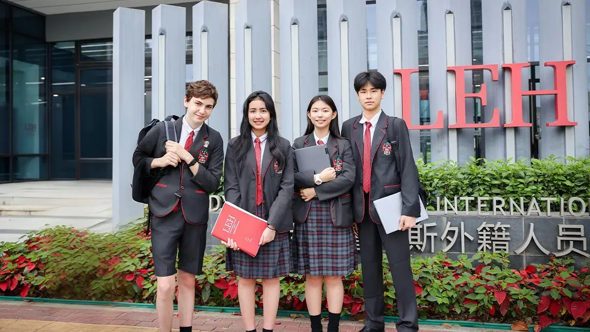 LEH International School Foshan students standing at campus entrance with school sign