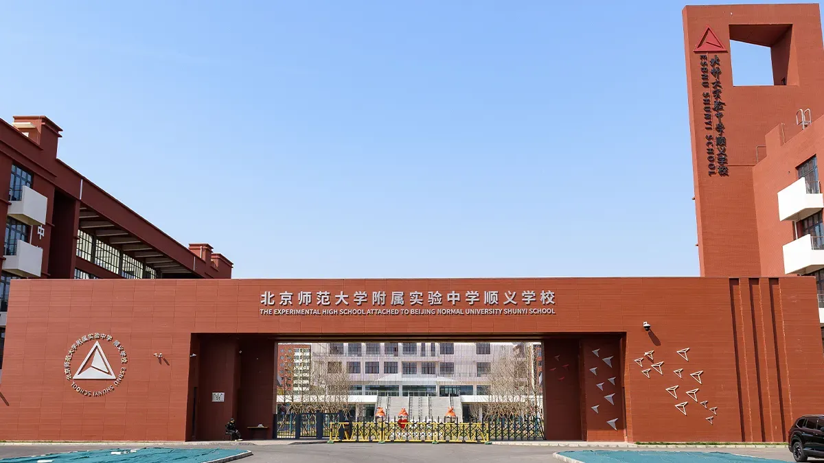 The Experimental High School Attached to Beijing Normal University Shunyi School — red-brick campus entrance gate with school name in Chinese and English