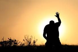 Kneeling prayer into sunrise
