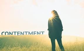 A peaceful sunrise with a person thinking of what it means to be content