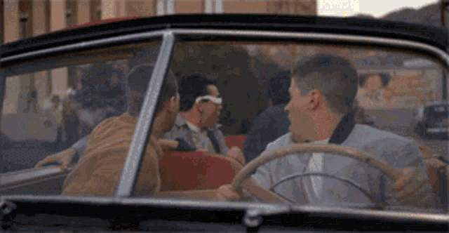 a group of people are sitting in a car talking