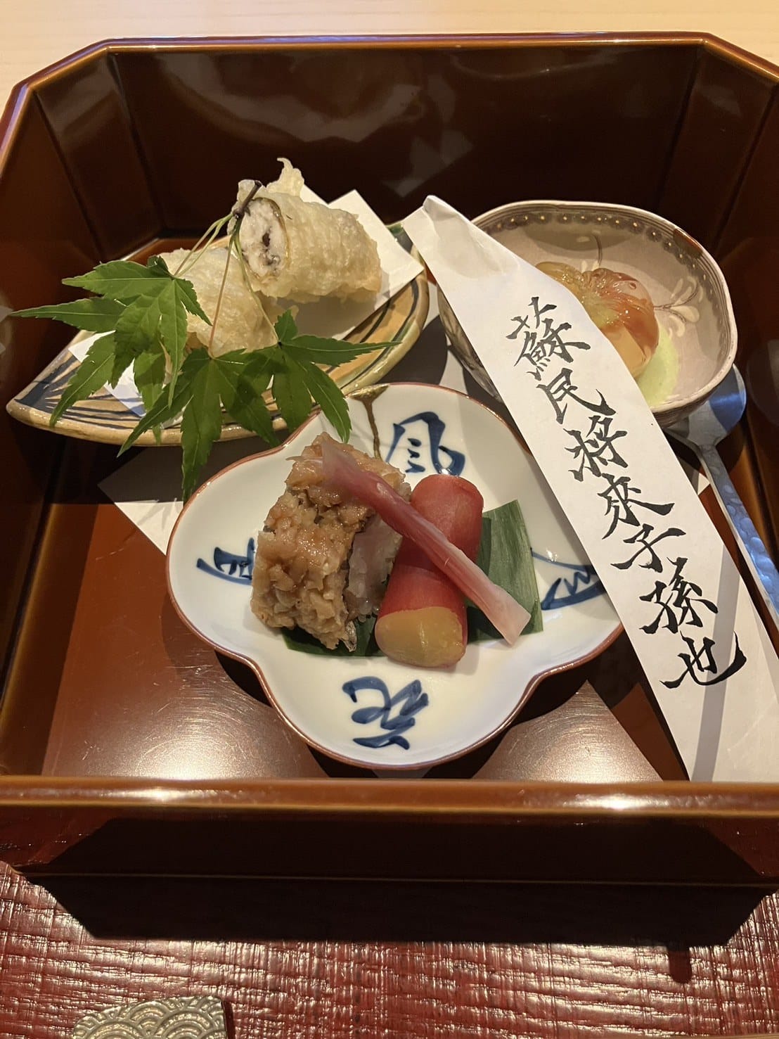 A lacquered kaiseki course box with tempura and seasonal appetizers at FUFU Kyoto