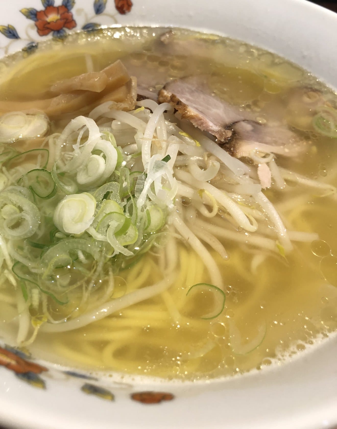 Bowl of Hakodate shio ramen with green onion, bean sprouts and pork chashu in clear salt-based broth