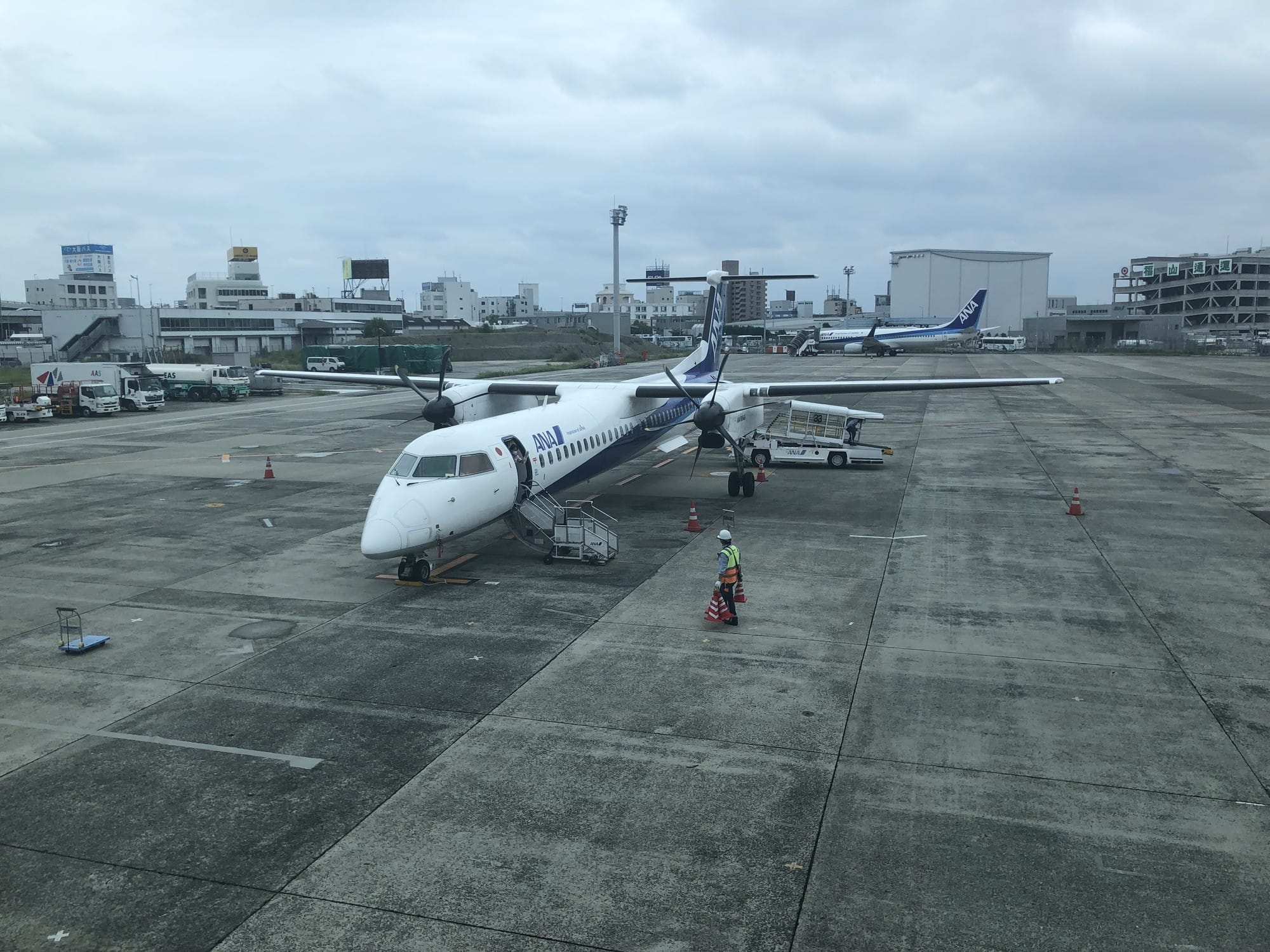An ANA turboprop on the apron at Osaka Itami Airport with ground crew