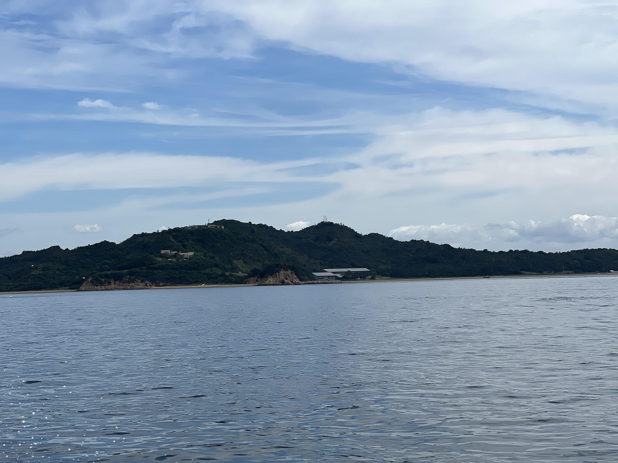 View of a Seto Inland Sea island from a ferry, wooded hills rising above the water