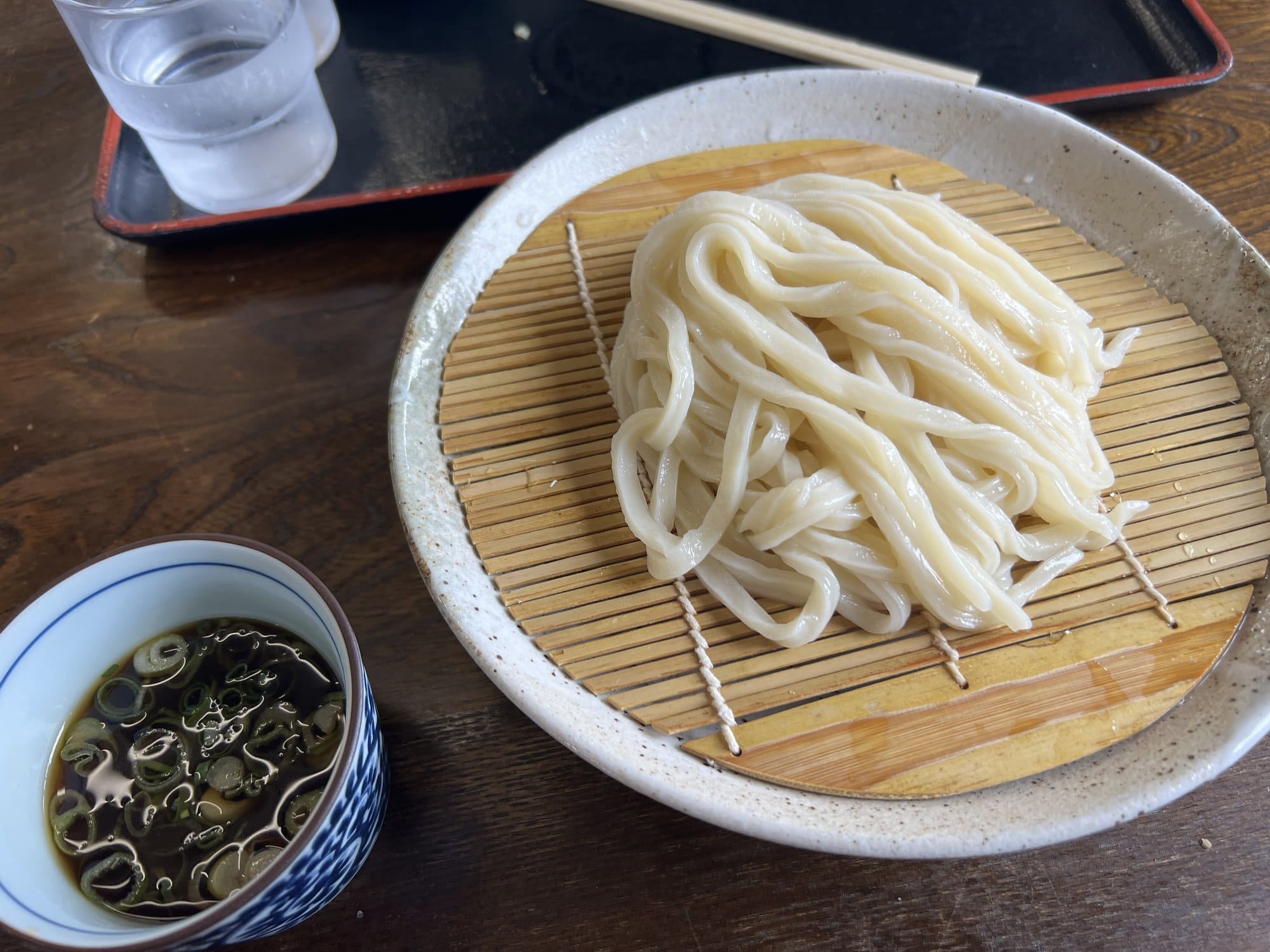 Freshly boiled Sanuki udon noodles served on a bamboo tray with dipping sauce