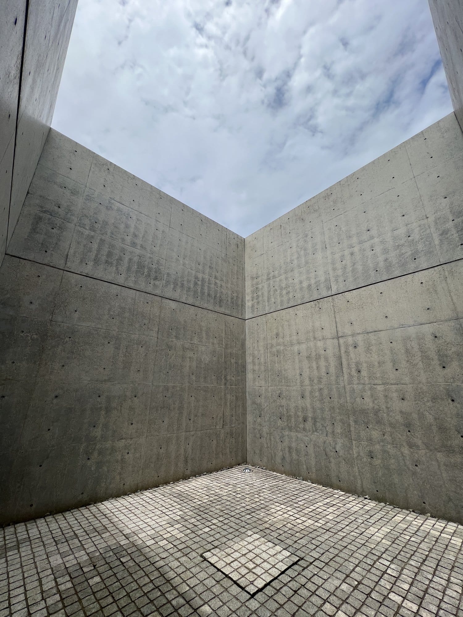 Concrete walls framing the sky at a modern museum courtyard in Kanazawa