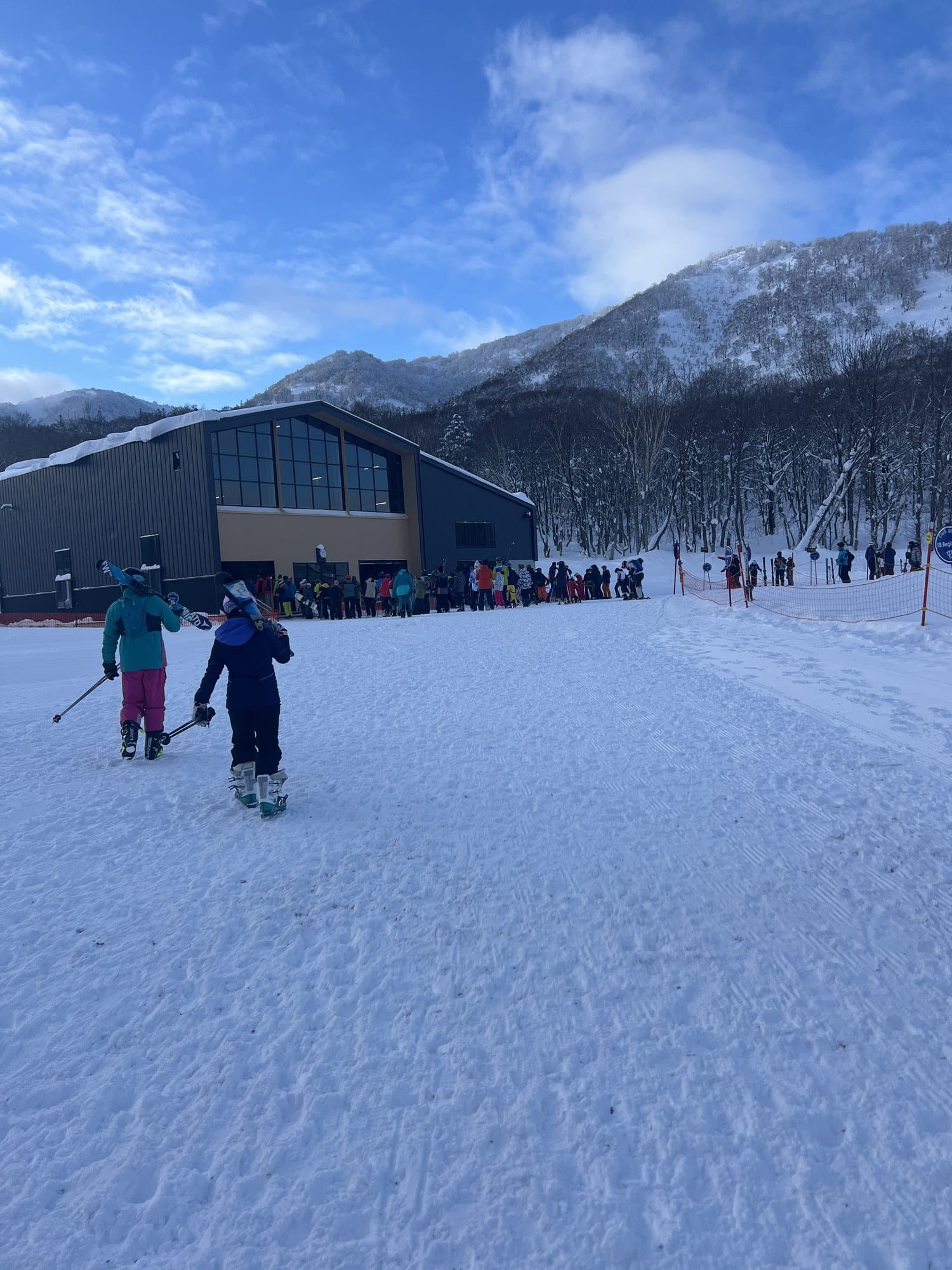 Skiers and ski school groups gathering at the Kiroro base area on a sunny January morning