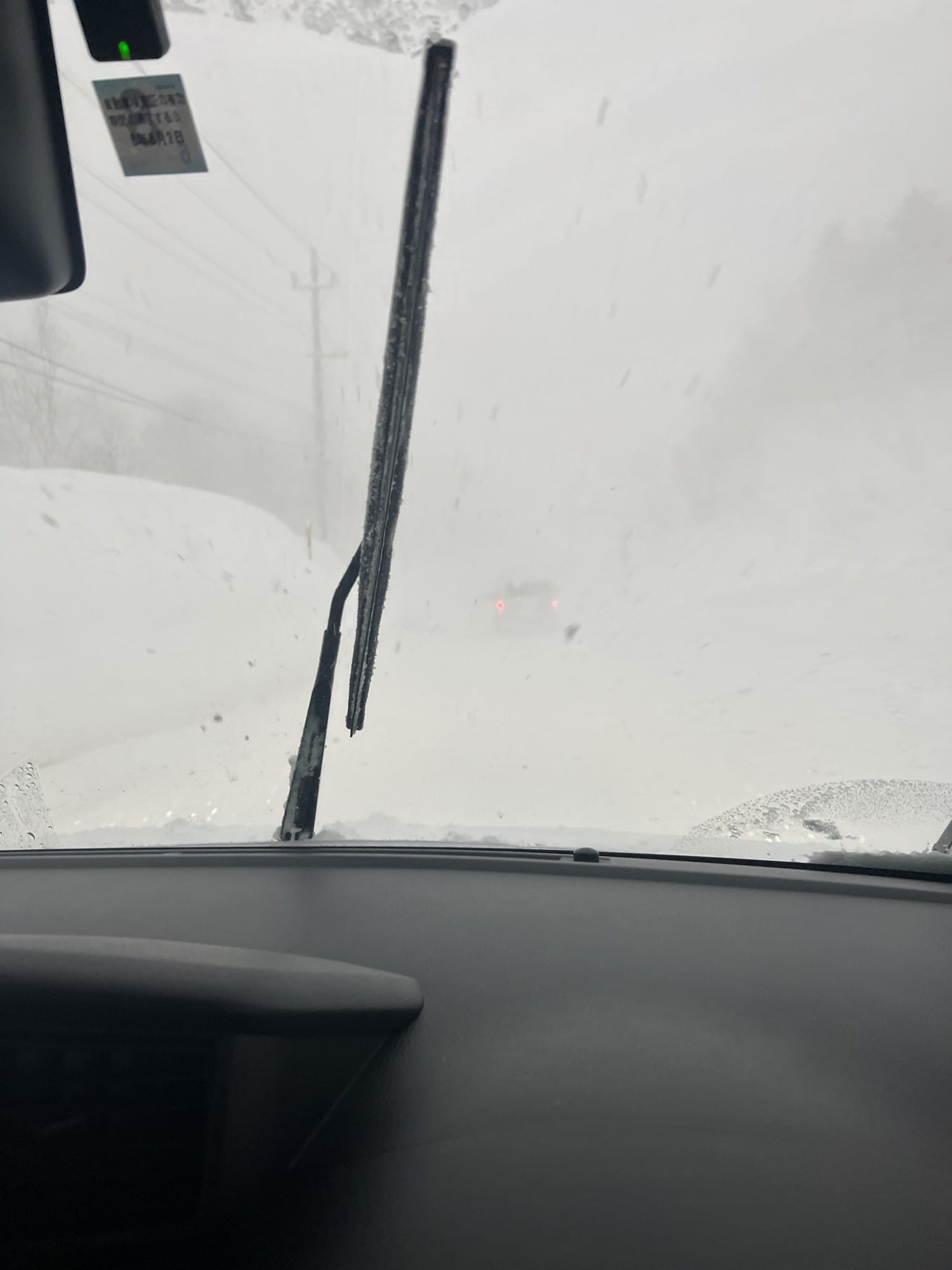 Conditions de white-out vues depuis l'habitacle, seuls les feux arrière de la voiture précédente restent visibles