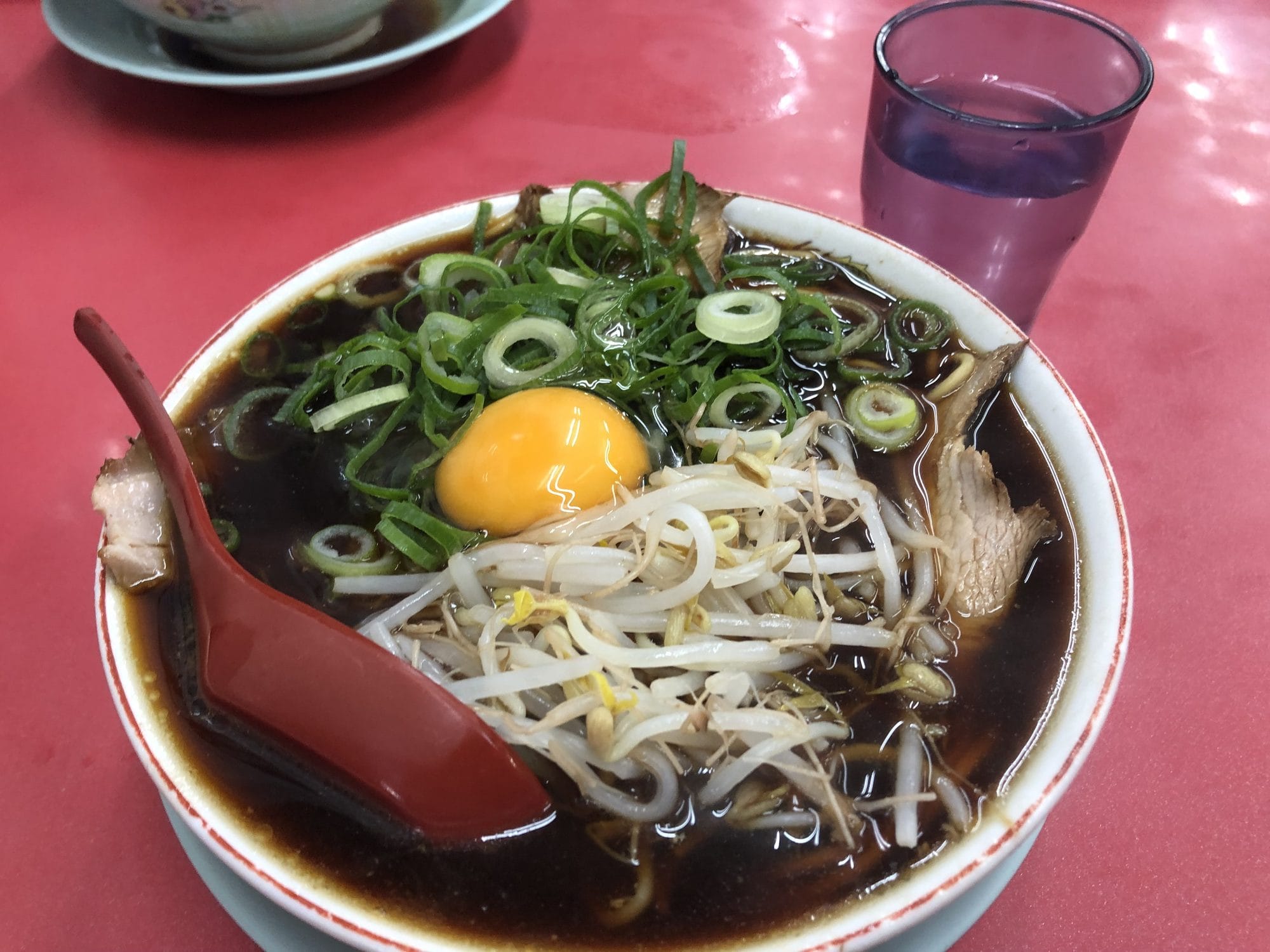 Bowl of Kyoto-style dark shoyu ramen with bean sprouts and spring onion