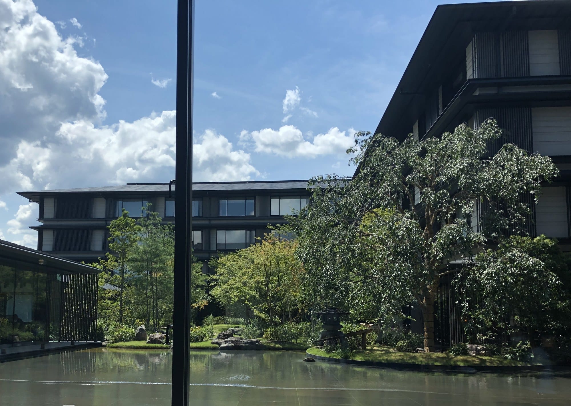 The courtyard garden and reflecting pond of HOTEL THE MITSUI KYOTO seen from the lobby lounge