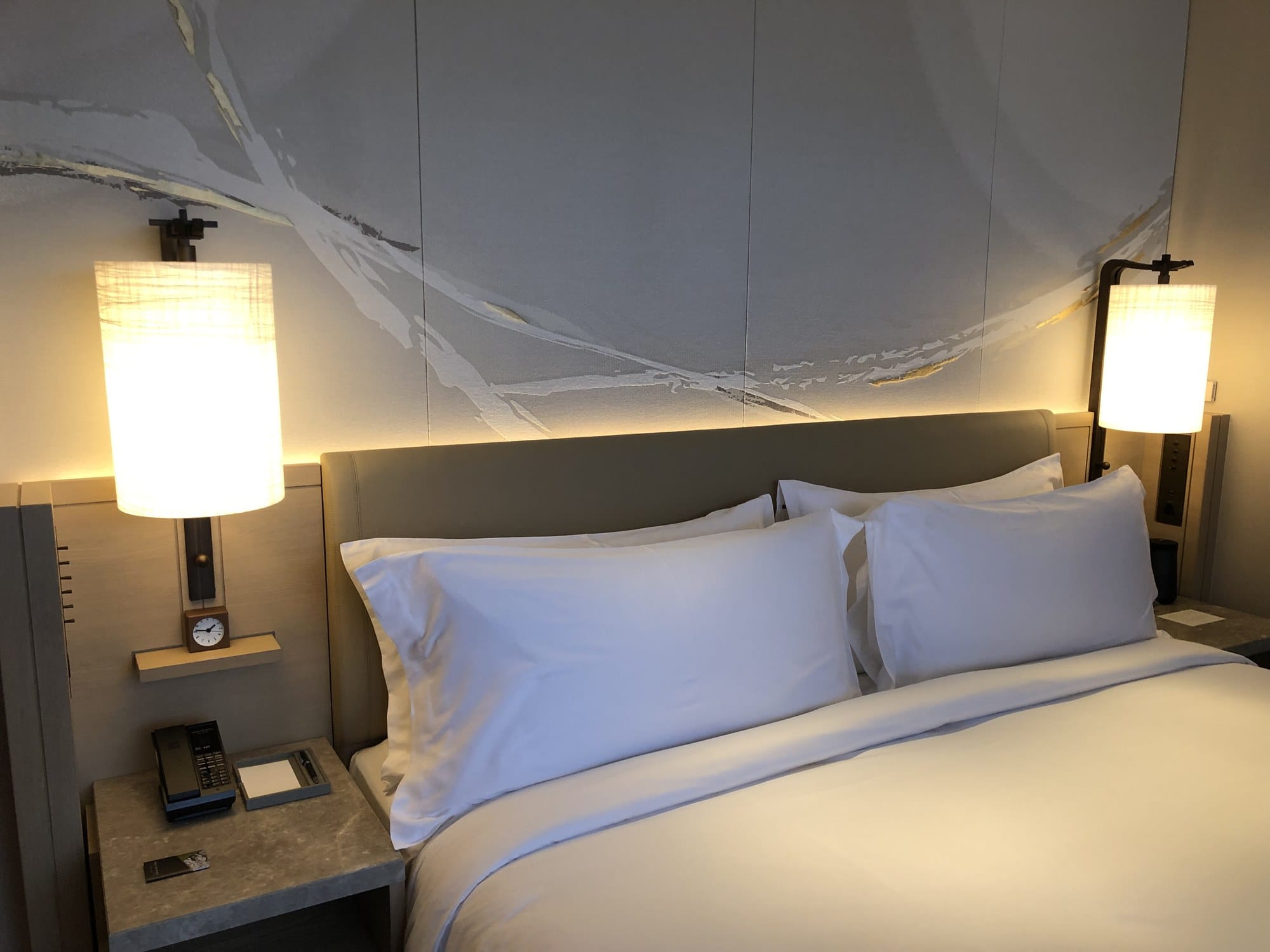 A king bed with washi-textured art wall and paper-shade lamps at HOTEL THE MITSUI KYOTO