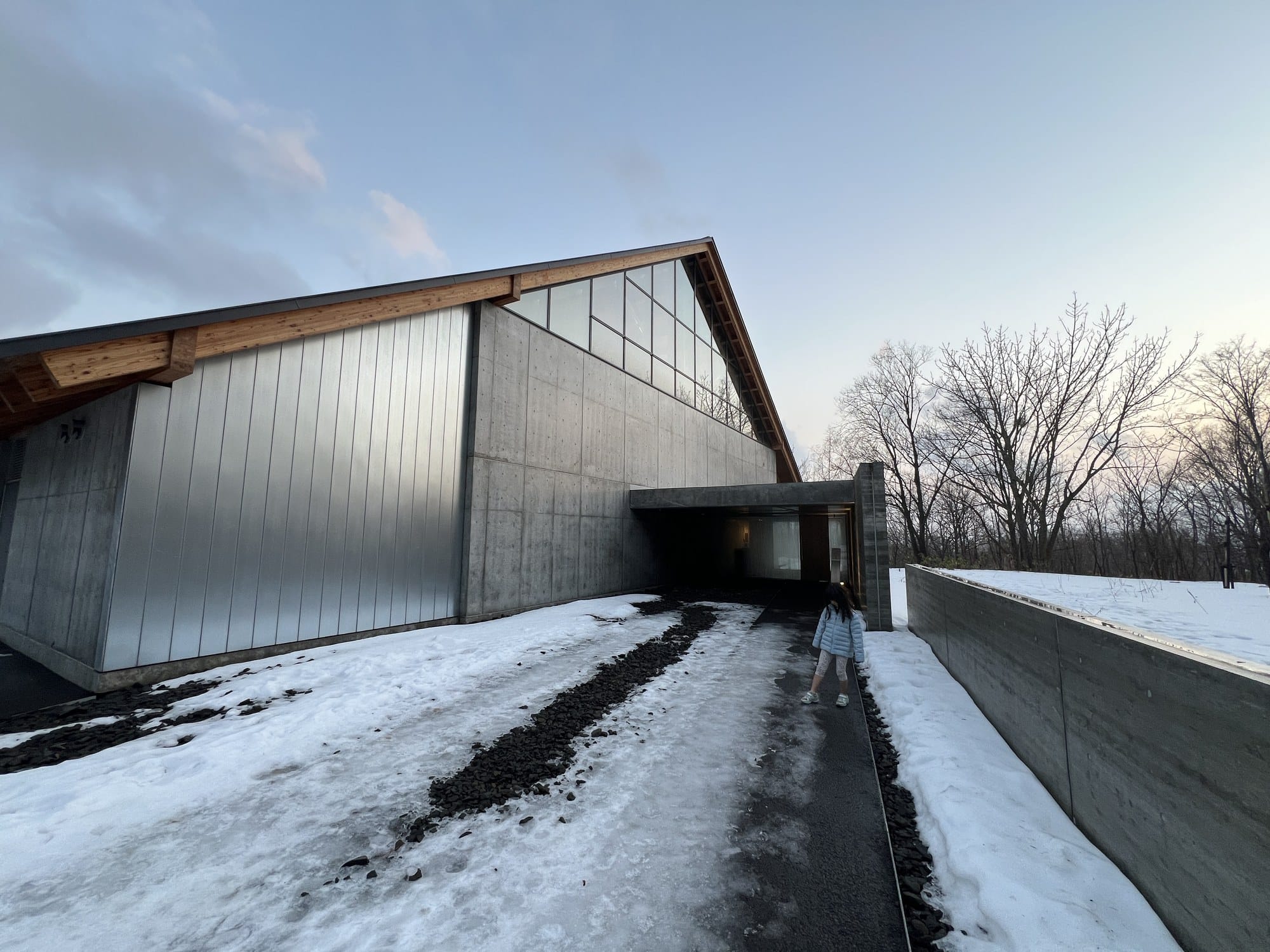 The concrete and metal-clad Niseko Distillery building in winter snow