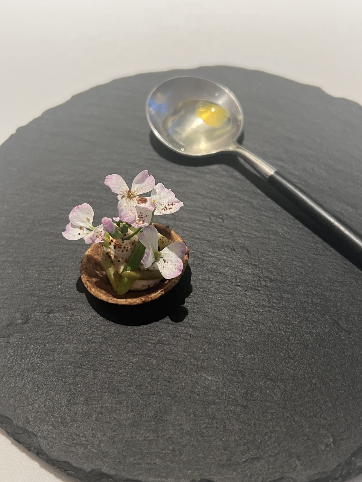 A flower-topped amuse-bouche served on slate at Otowa Restaurant in Utsunomiya