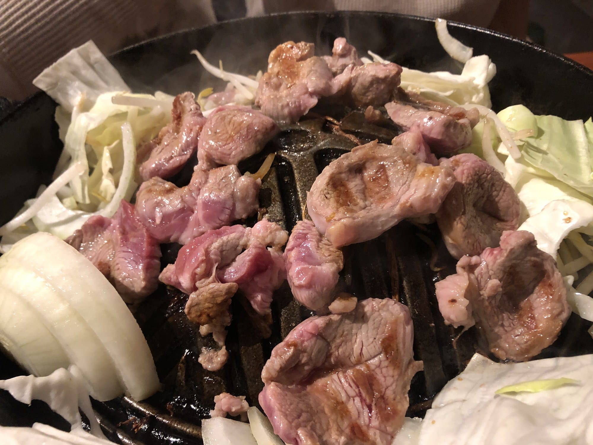 Jingisukan grilled mutton with cabbage and onion on a cast-iron pan