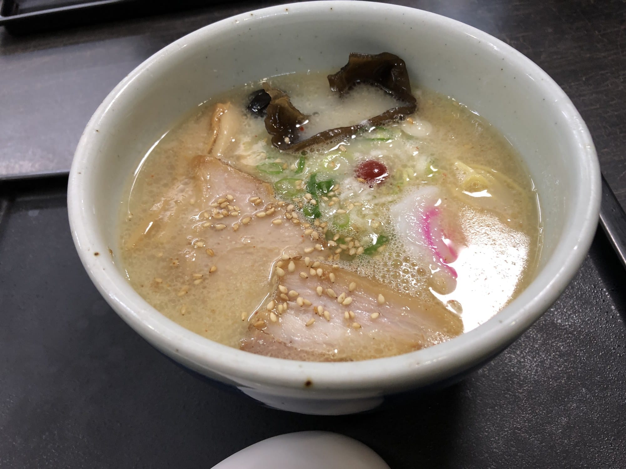 A bowl of Santoka shio ramen with char siu, kikurage and a pickled plum