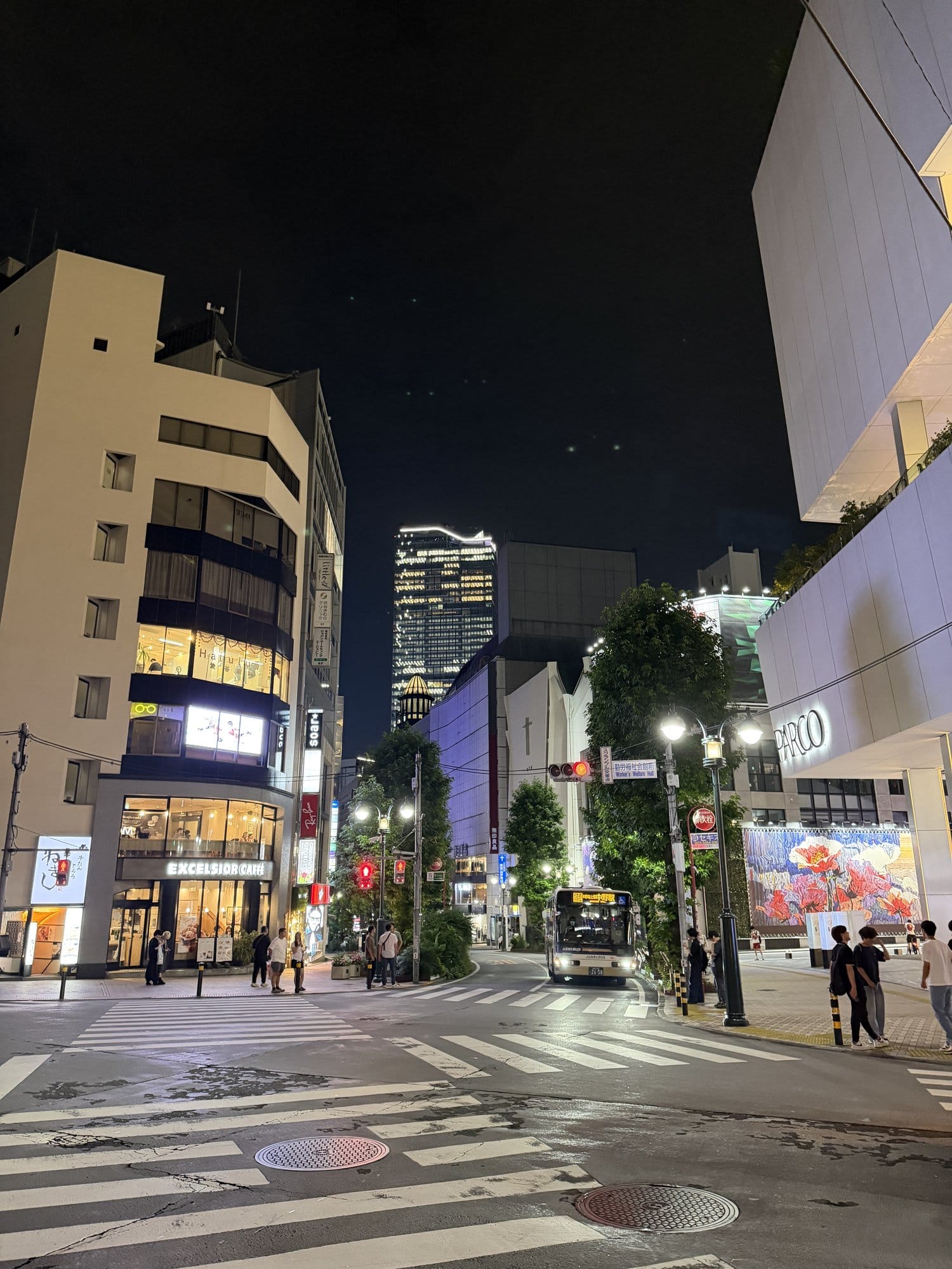 Shibuya backstreet at night near PARCO with Shibuya Scramble Square lit in the distance