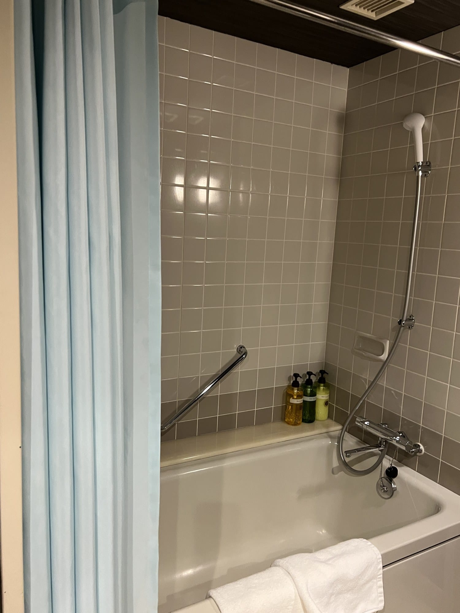 A tiled bathroom with shower and tub at Tomamu The Tower