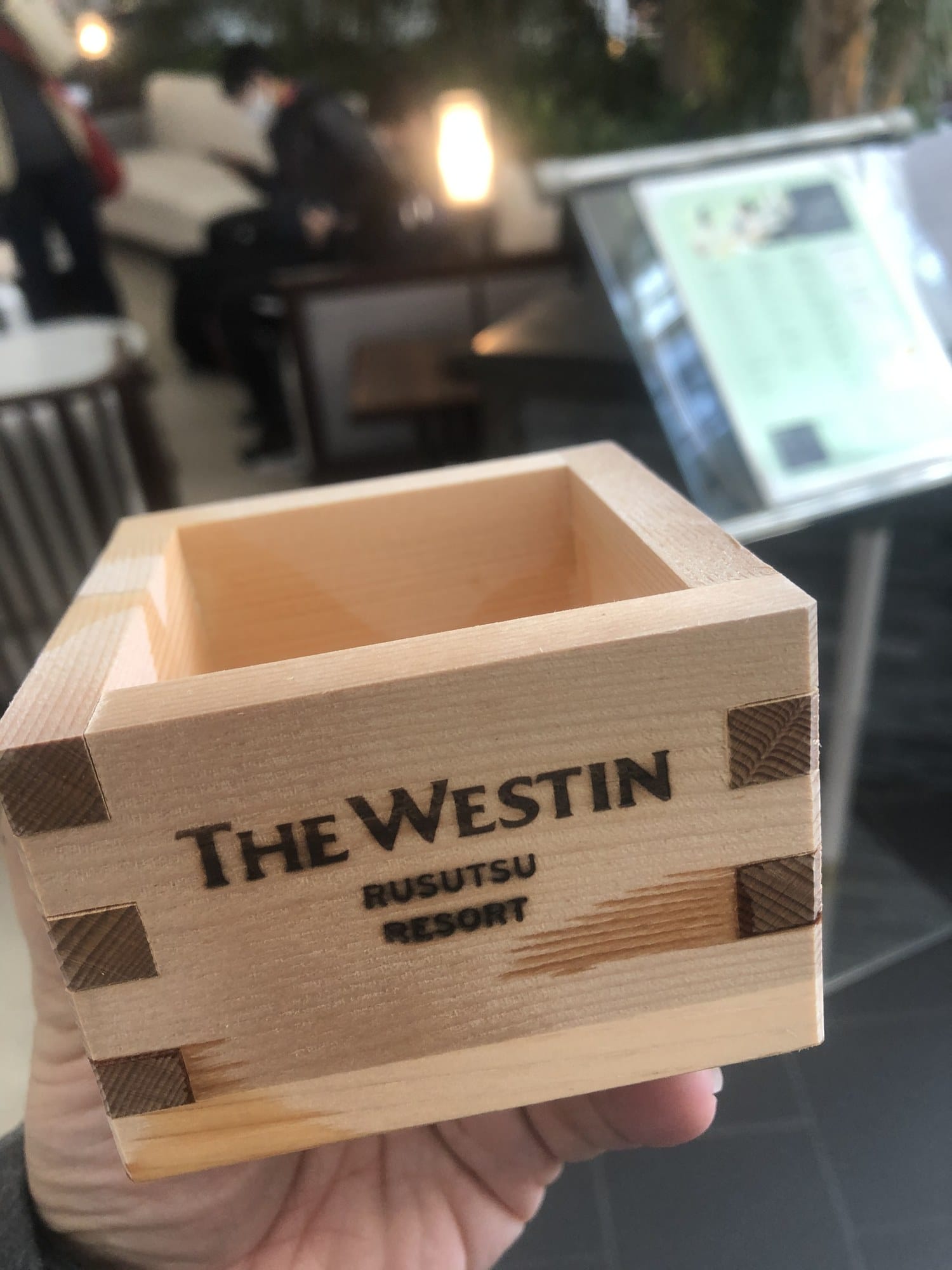 A wooden masu sake cup branded The Westin Rusutsu Resort