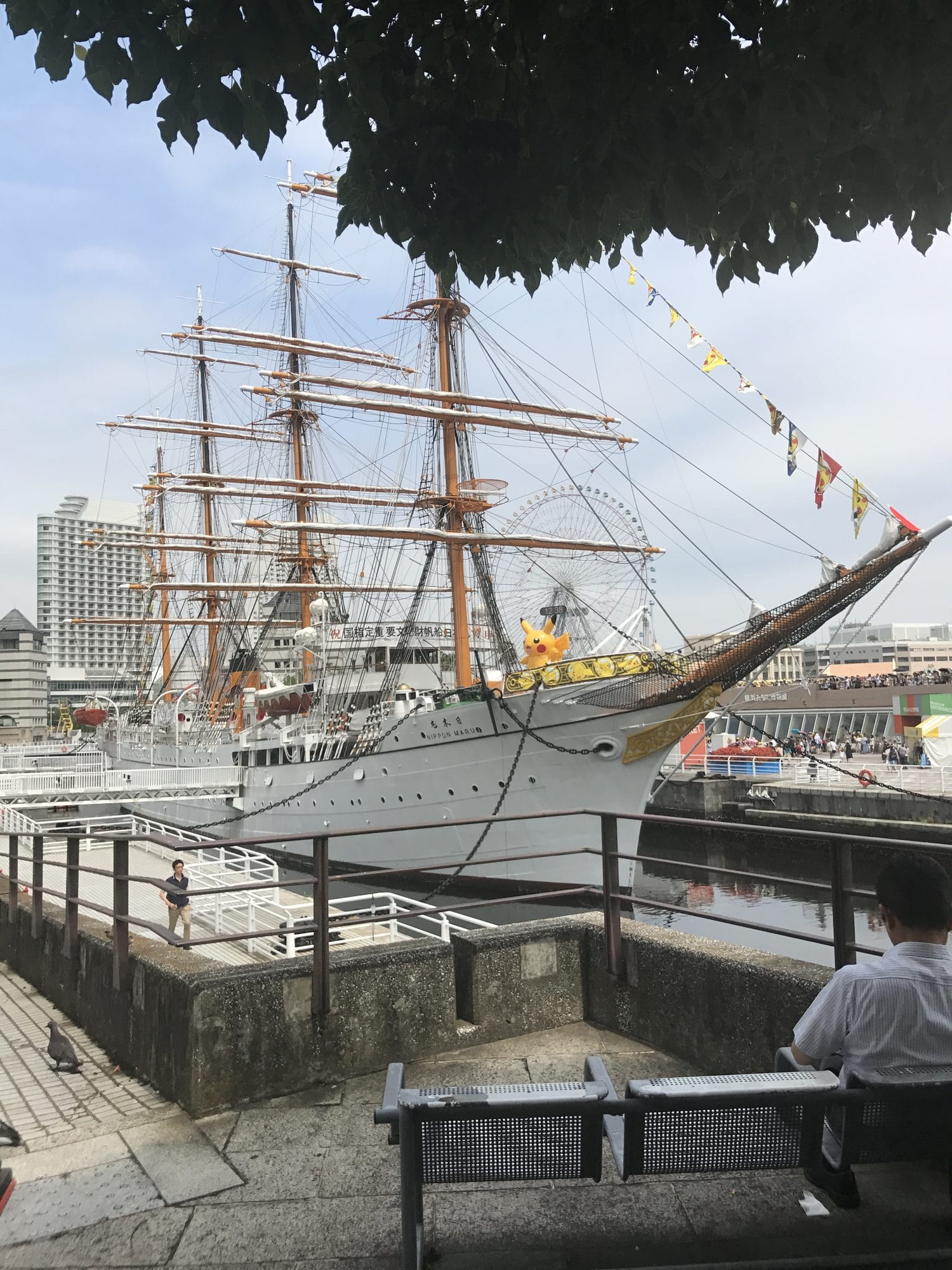 Historic Nippon Maru sailing ship moored at Yokohama harbour with the Minato Mirai skyline and Ferris wheel in the background