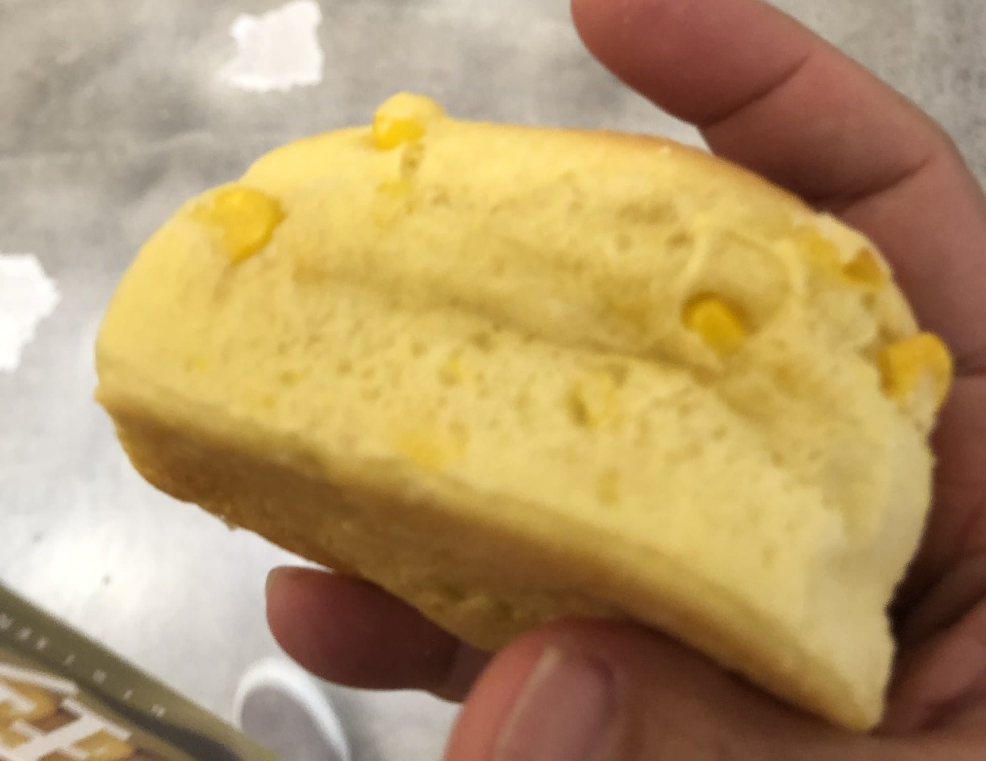 A split New Chitose Airport cornpan showing whole sweetcorn kernels through the pale crumb