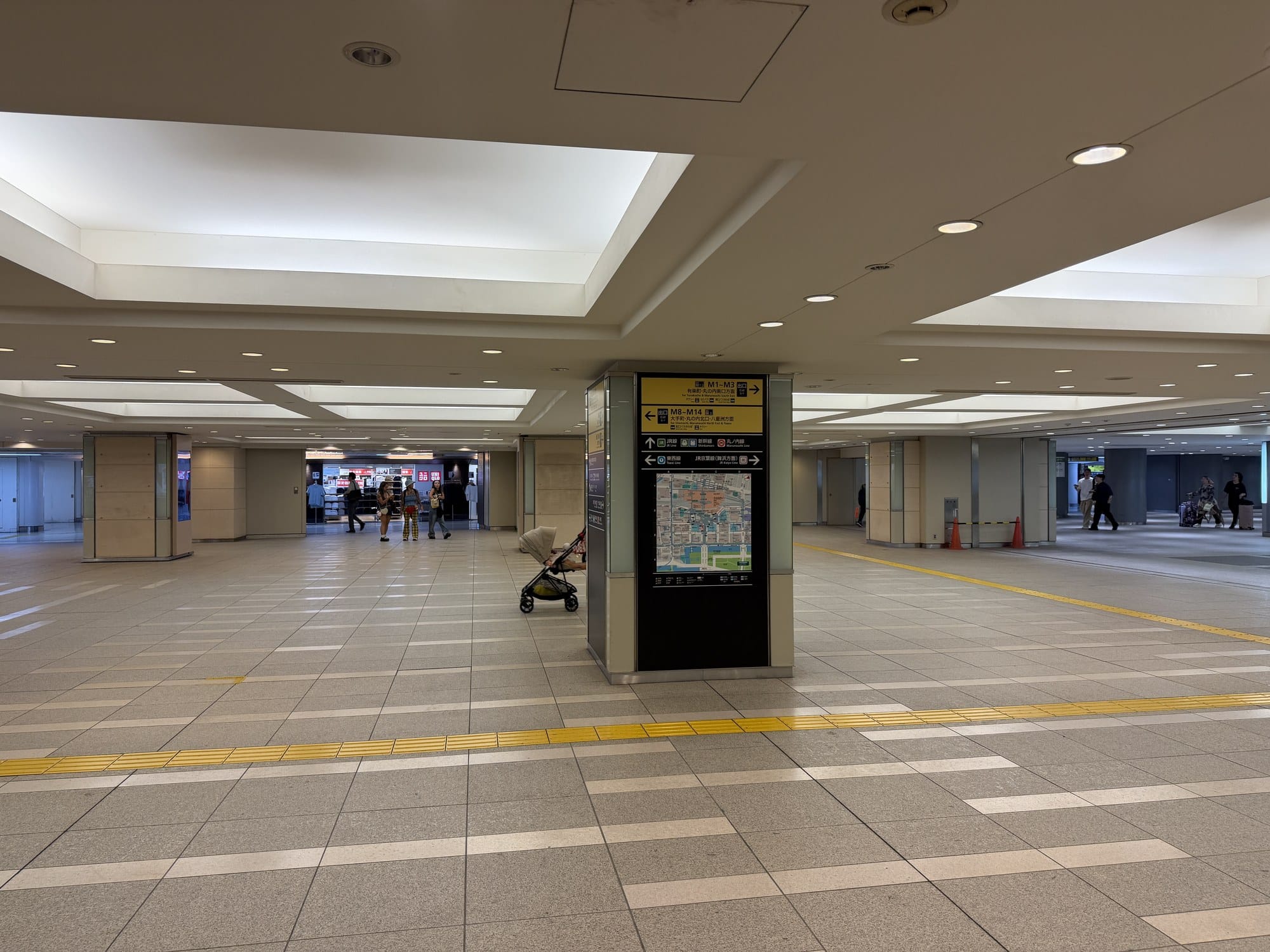 General information pillar in Tokyo Station's Marunouchi underground plaza listing exits M1 to M3, M8 to M14, and directions to JR lines, the shinkansen, the Marunouchi Line, the Tozai Line, and the JR Keiyo Line