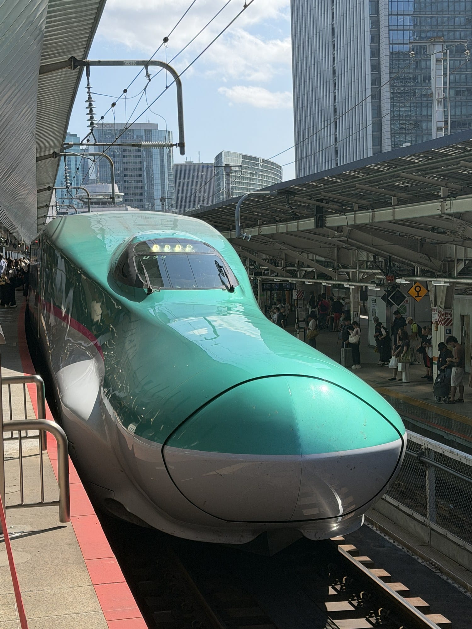 Green-nosed E5 series Hayabusa shinkansen train at a platform