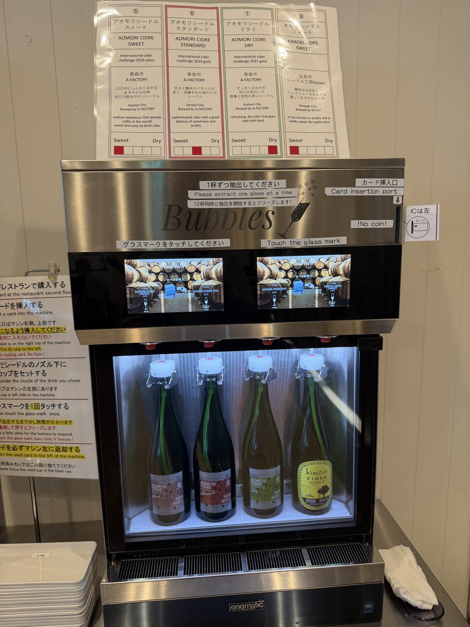 Tasting cards above the A-FACTORY cider machine showing International Cider Challenge awards and a Sweet-Dry scale for each Aomori cider