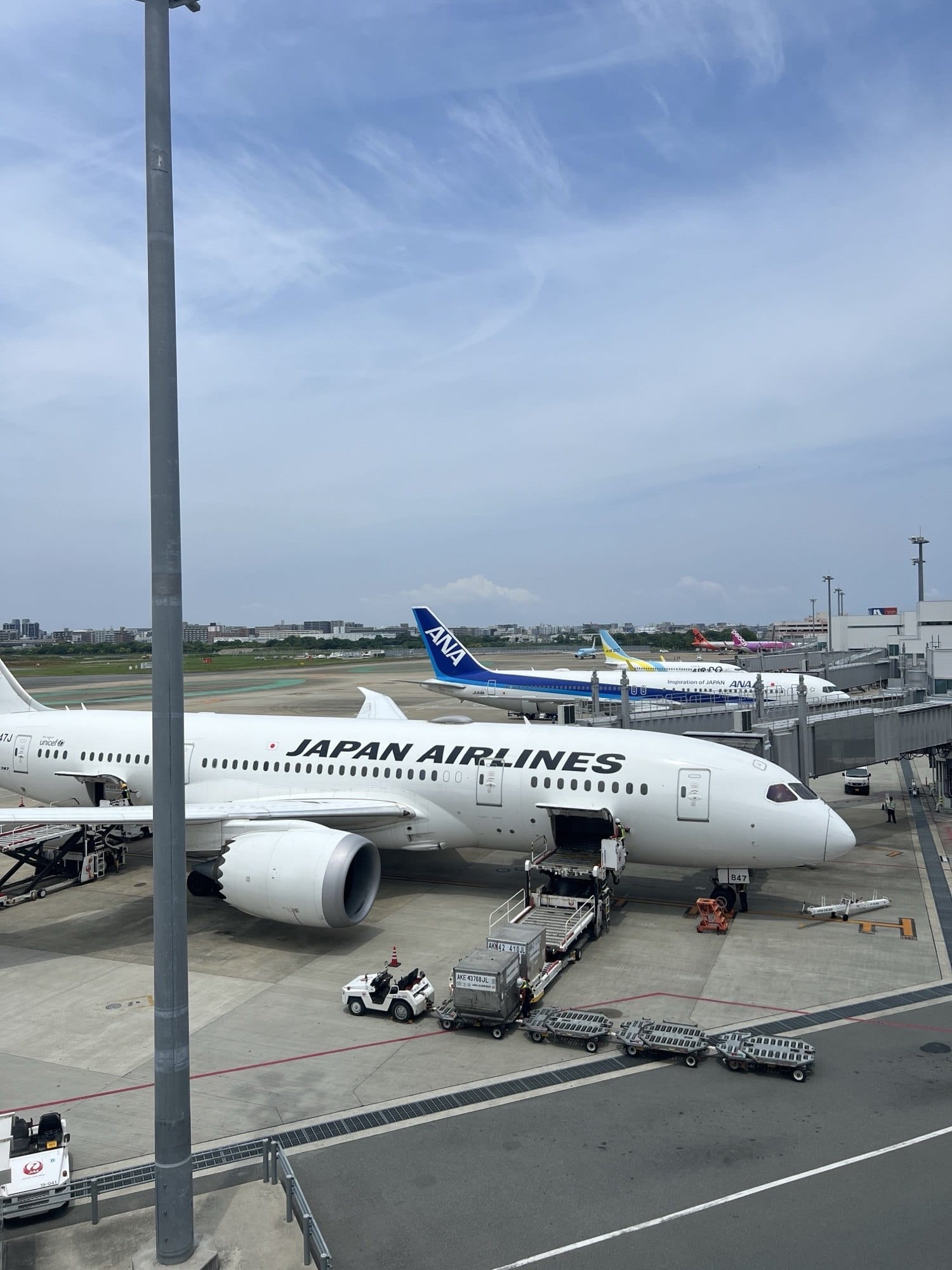 A JAL Airbus A350 at Haneda gate B47 with ANA and Peach aircraft parked behind it